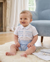 Carriage Boutique baby boy wearing a white button-down shirt with blue hand smocking and light blue shorts