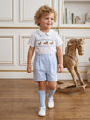Carriage Boutique baby boy wearing a white and light blue smocked bobby suit with carousel horse embroidery