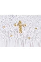 Carriage Boutique white cotton baby christening dress featuring intricate hand smocking and a gold cross detail