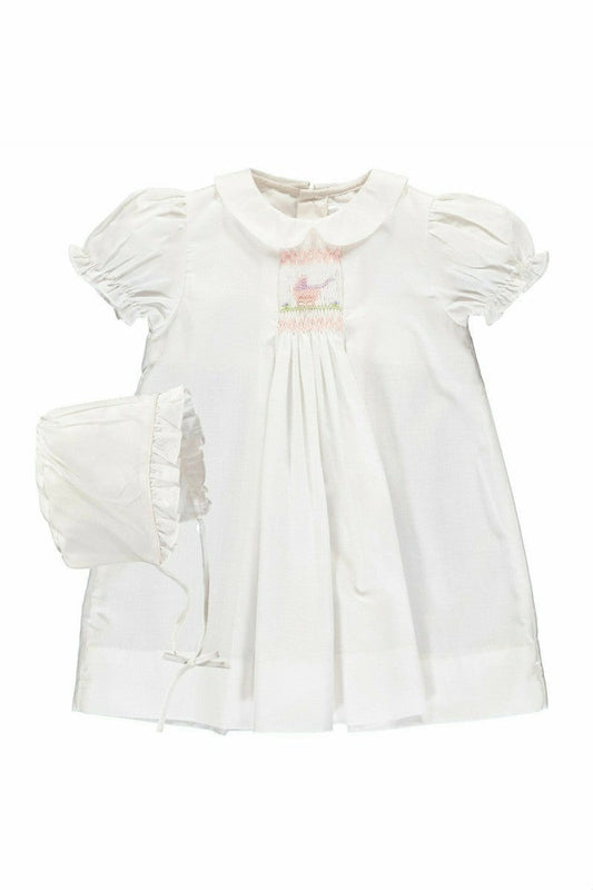 Carriage Boutique white smocked heirloom dress with pram embroidery, Peter Pan collar, and matching ruffled bonnet.