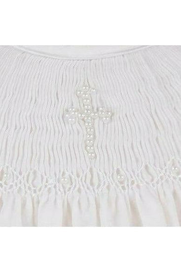 Carriage Boutique white cotton baby dress featuring intricate hand smocking and a delicate pearl cross detail.