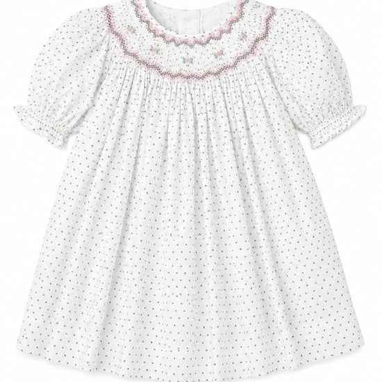 Carriage Boutique baby girl dress in off-white with black polka dots, smocked yoke, and floral embroidery.