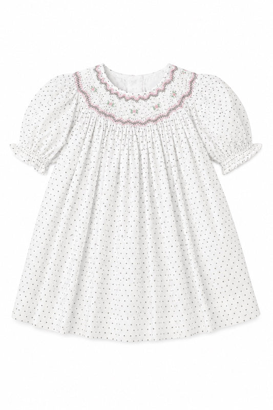 Carriage Boutique baby girl dress in off-white with black polka dots, smocked yoke, and floral embroidery.