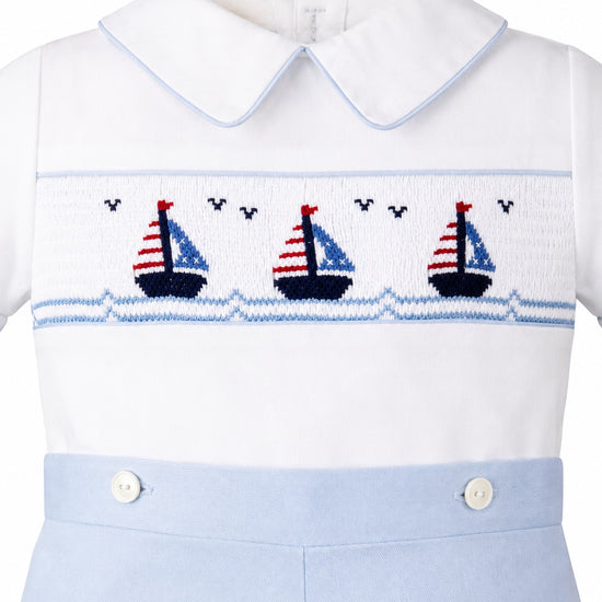 Carriage Boutique white cotton bobby suit with blue trim and smocked sailboat embroidery on the chest