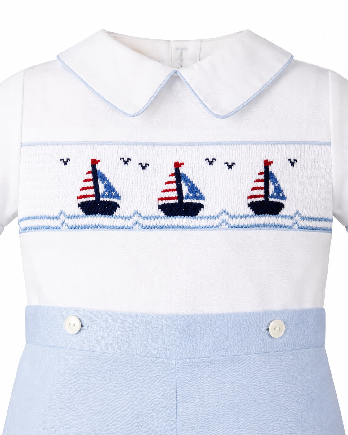 Carriage Boutique white cotton bobby suit with blue trim and smocked sailboat embroidery on the chest
