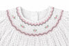 Carriage Boutique off-white baby dress with smocked yoke, pink and green floral embroidery, and tiny black star print.