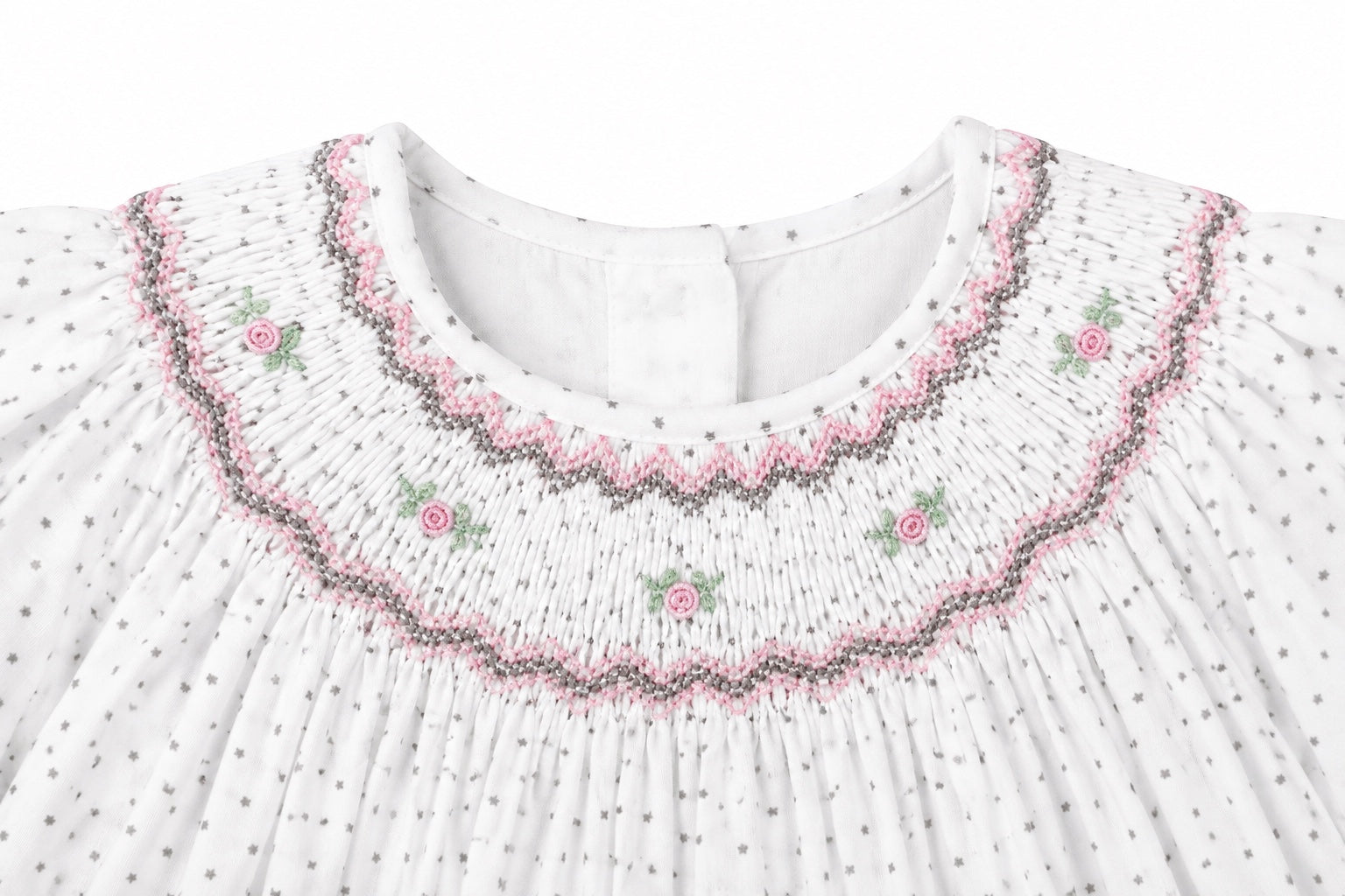 Carriage Boutique off-white baby dress with smocked yoke, pink and green floral embroidery, and tiny black star print.