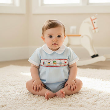 Carriage Boutique light blue baby boy romper with smocked train detail and white collar. Comfortable for everyday wear.