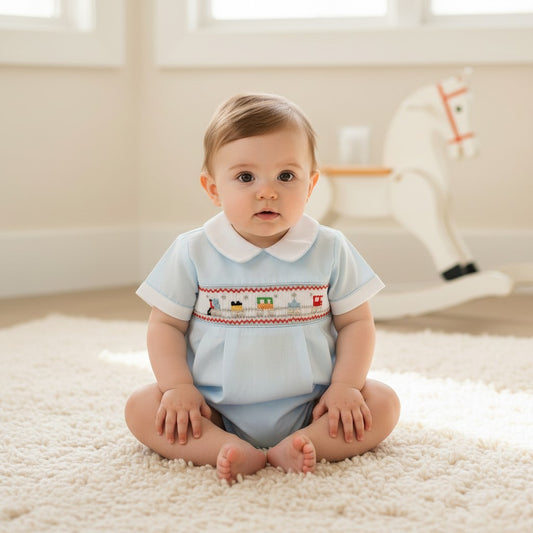 Carriage Boutique light blue baby boy romper with smocked train detail and white collar. Comfortable for everyday wear.
