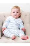 Baby wearing a Carriage Boutique white and sky-blue striped long-sleeve top and legging set while sitting in a chair.