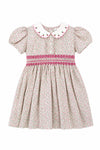 Carriage Boutique toddler girl dress in tan floral cotton with puff sleeves, smocked red diamond detail, and collar.