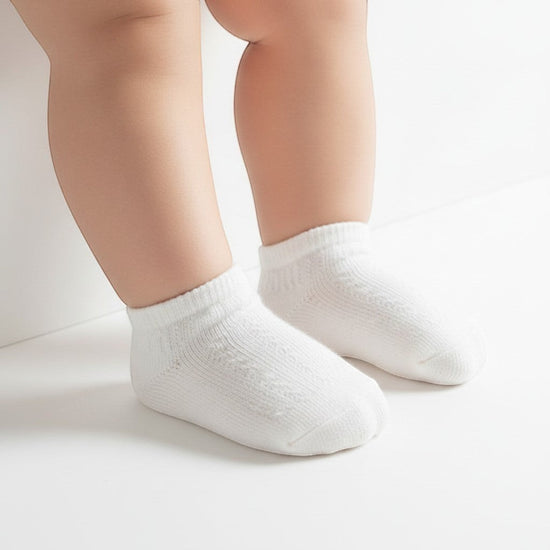 Carriage Boutique baby girls white ankle socks with a delicate diamond pattern and ribbed cuff on infant feet