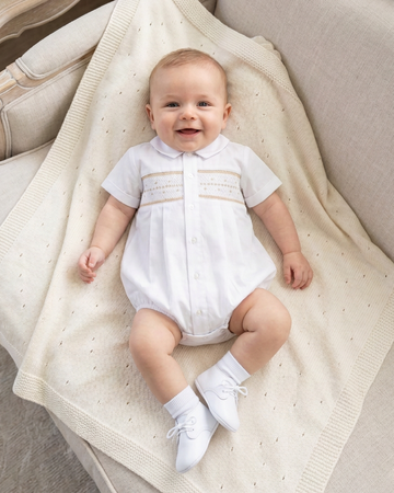 Carriage Boutique white baby boy christening bubble with smocked embroidery and Peter Pan collar on a cream blanket
