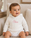 Carriage Boutique white cotton cable knit hooded baby sweater with personalized pink embroidery on the chest.