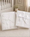 Carriage Boutique Julius Berger white christening blanket with floral accents and fringe in a gift box.
