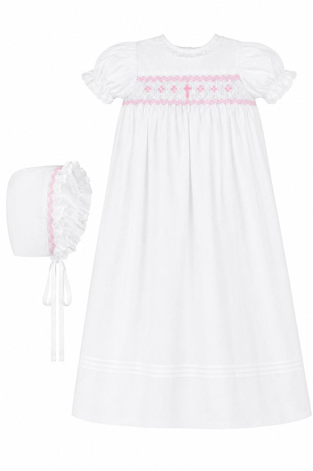 Carriage Boutique white christening gown with pink hand-smocked yoke, embroidered cross, and matching ruffled bonnet.