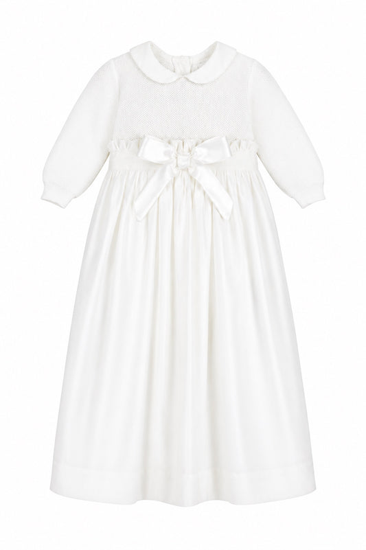 Carriage Boutique white baby girl christening gown with pebble stitch bodice, Peter Pan collar, and satin waist bow.