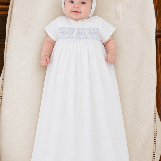 Carriage Boutique baby boy white christening gown with hand-smocked yoke and baby blue cross detail, includes bonnet.
