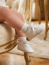 Carriage Boutique white baby boy christening shoes with cross embroidery worn with delicate lace-trimmed socks