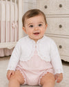 Carriage Boutique white cotton knit bolero shrug with textured pattern and single button on a baby girl