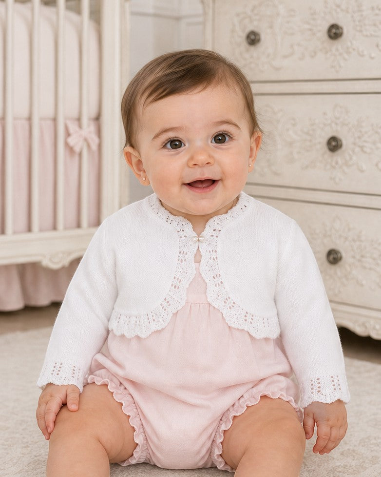 Carriage Boutique white cotton knit bolero shrug with textured pattern and single button on a baby girl