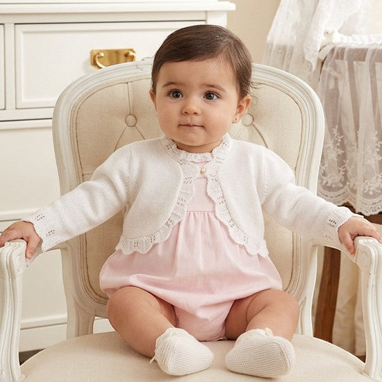 Carriage Boutique white cotton bolero shrug with textured knit pattern and single button on a baby girl