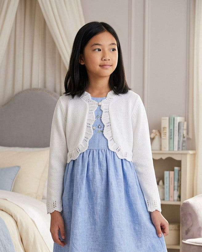 Carriage Boutique white cotton bolero shrug with textured knit pattern and single button closure worn by a young girl