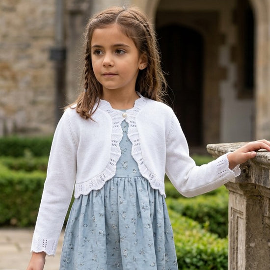 Carriage Boutique white cotton knit bolero shrug with textured pattern and single button closure on a young girl