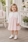 Carriage Boutique white cotton bolero shrug with textured knit pattern worn by a toddler girl over a pink dress