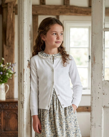 Carriage Boutique white cotton cashmere cardigan worn by a young girl with a floral dress and lace collar