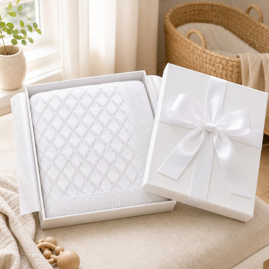 Carriage Boutique white cotton baby knit blanket with shell texture in a gift box with a satin ribbon.