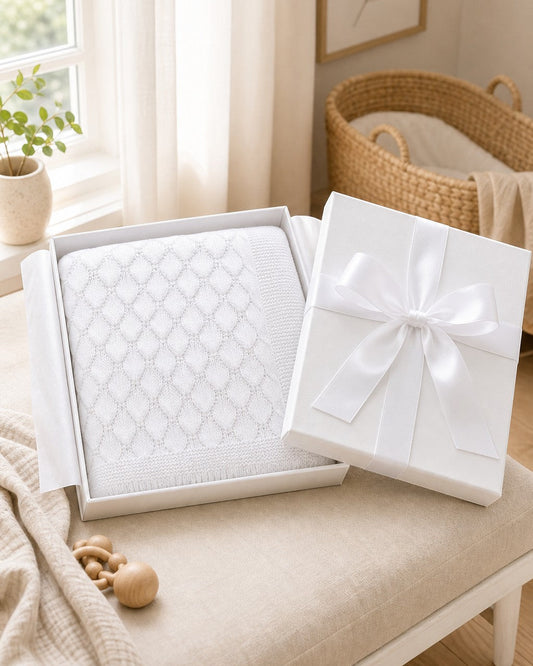 Carriage Boutique white cotton baby knit blanket with shell texture in a gift box with a satin ribbon.