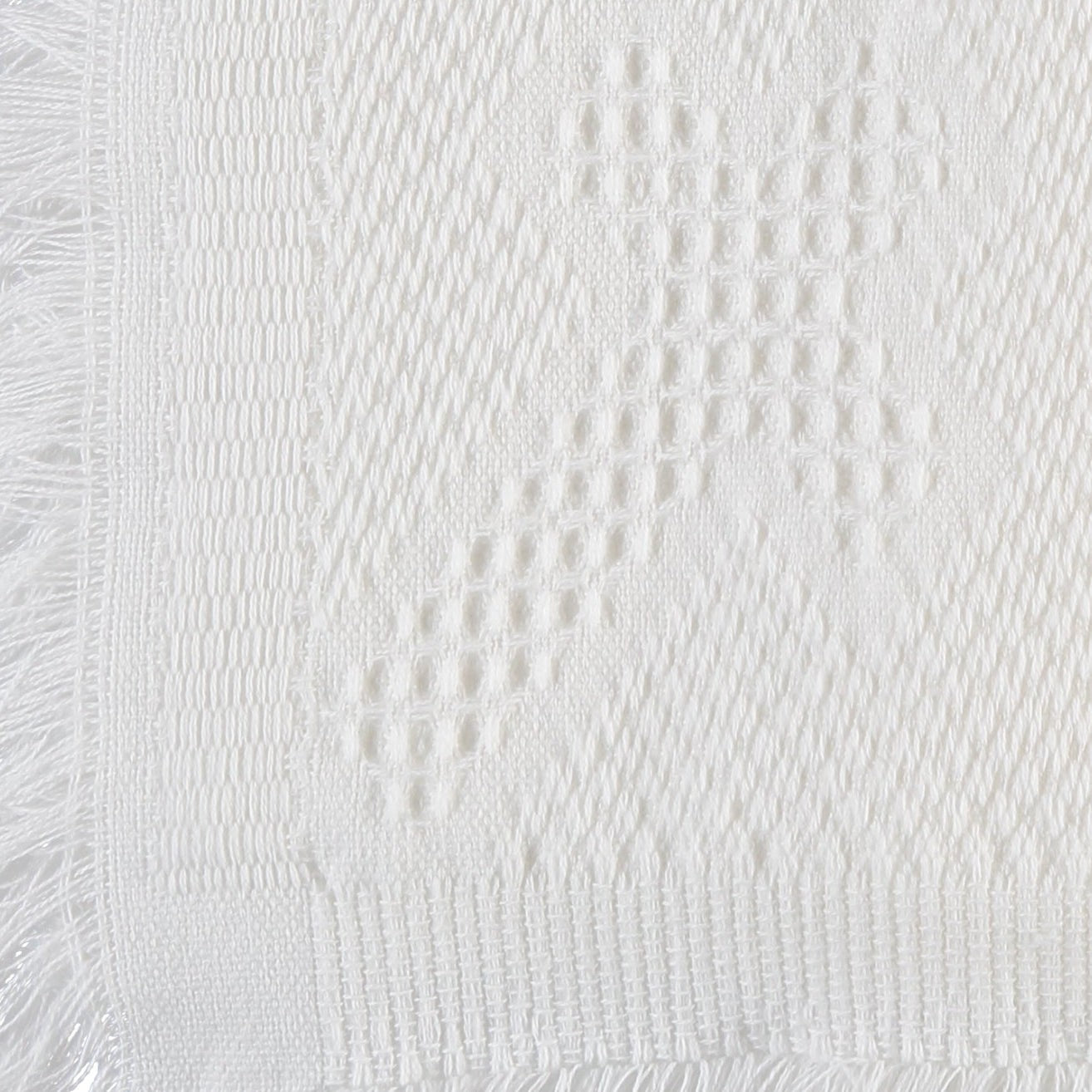Carriage Boutique white baby blanket featuring a delicate woven cross pattern and elegant fringe trim detail.