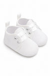 Carriage Boutique white baby christening shoes with satin ribbon laces and a delicate embroidered cross detail.