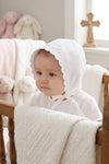Carriage Boutique white cotton christening bonnet with embroidered cross, scalloped edges, and satin ribbon ties.