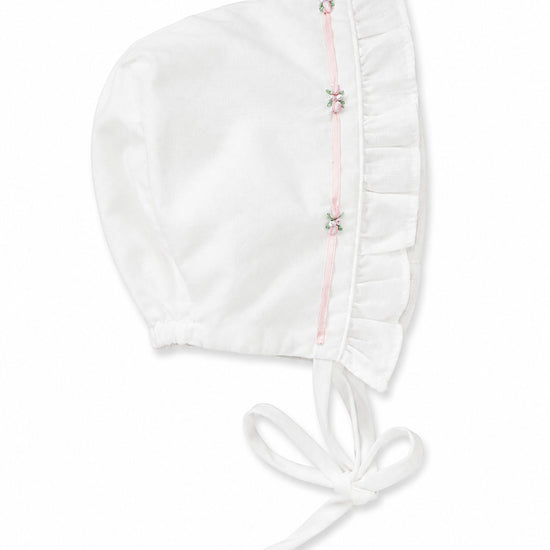 Carriage Boutique white baby bonnet with pink ribbon trim and delicate floral embroidery details