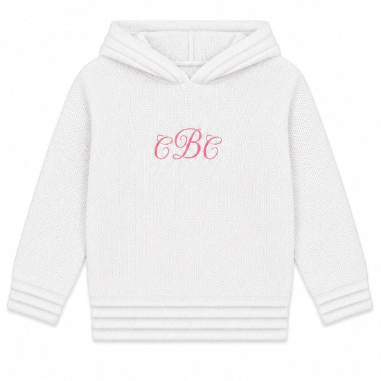 Carriage Boutique white hooded baby sweater with pink monogram embroidery on the chest and ribbed hem details.