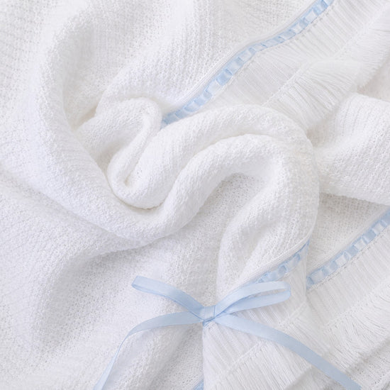 Carriage Boutique white knit baby blanket with blue satin ribbon trim and a delicate bow accent