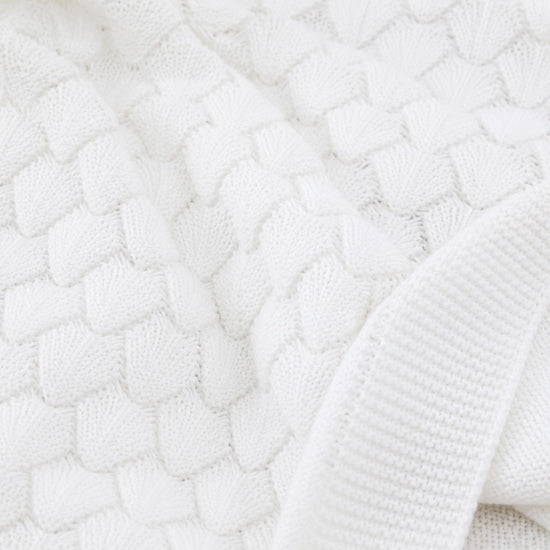 Carriage Boutique white cotton baby blanket with a textured shell-like knit pattern for cribs and strollers.