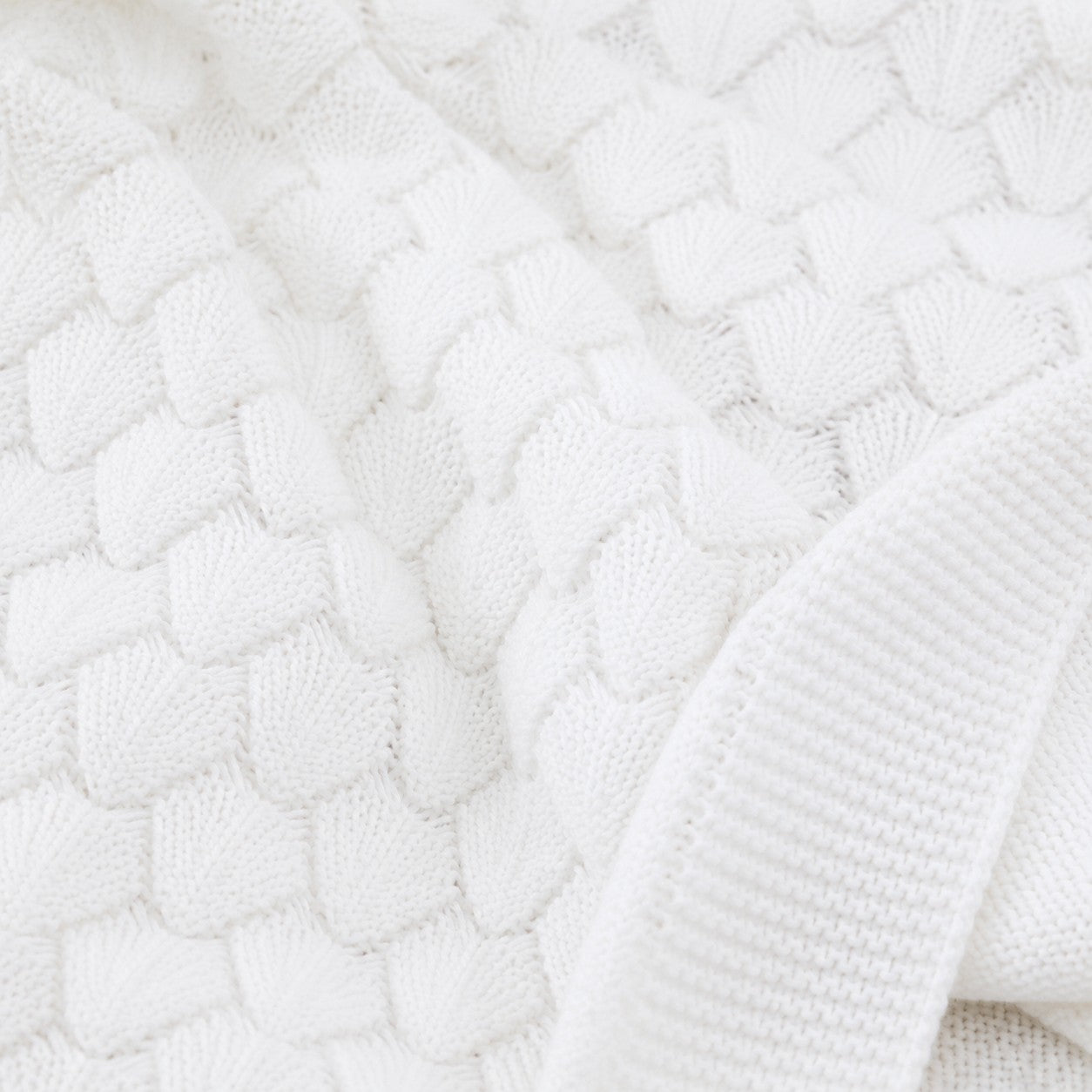 Carriage Boutique white cotton baby blanket with a textured shell-like knit pattern for cribs and strollers.