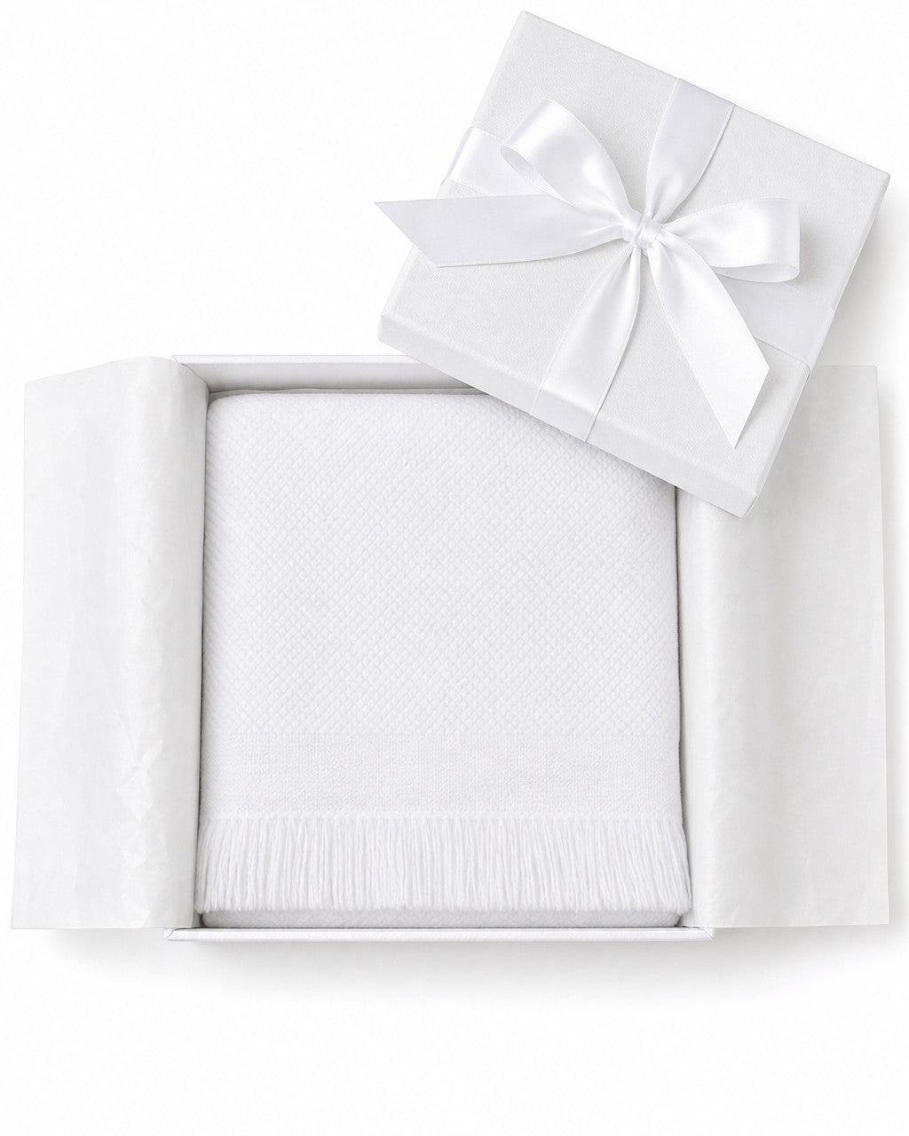 Carriage Boutique white knit baby blanket with fringe detail, presented in a gift box with a satin ribbon.