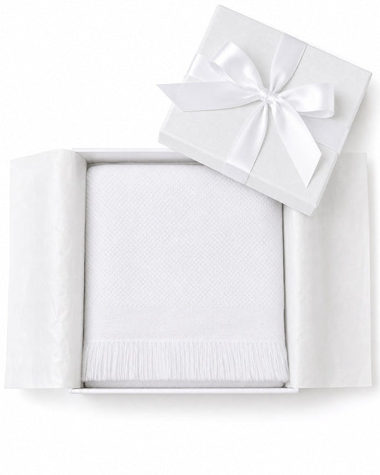 Carriage Boutique white knit baby blanket with fringe detail, presented in a gift box with a satin ribbon.