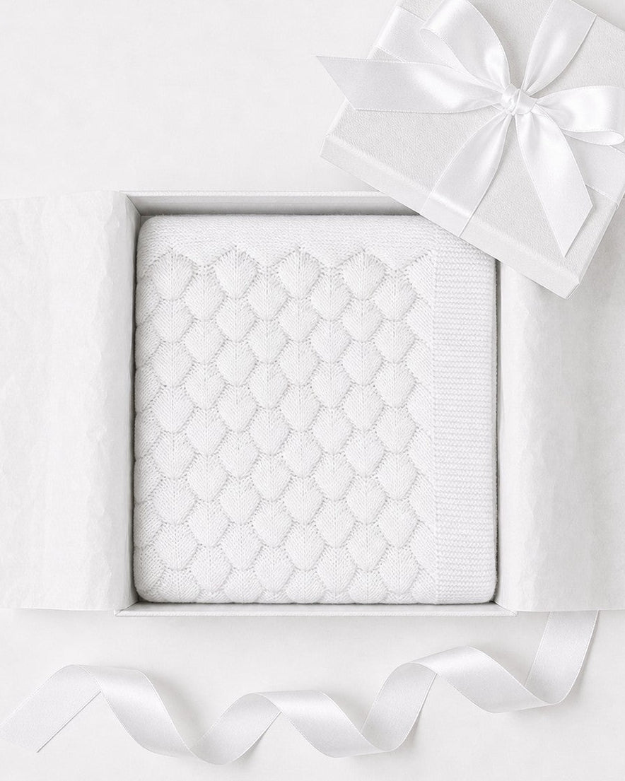 Carriage Boutique white cotton knit baby blanket with shell texture in a gift box with a satin ribbon.
