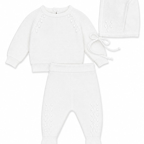 Carriage Boutique white knit baby boy christening outfit with leaf embroidery, long-sleeve top, pants, and bonnet.