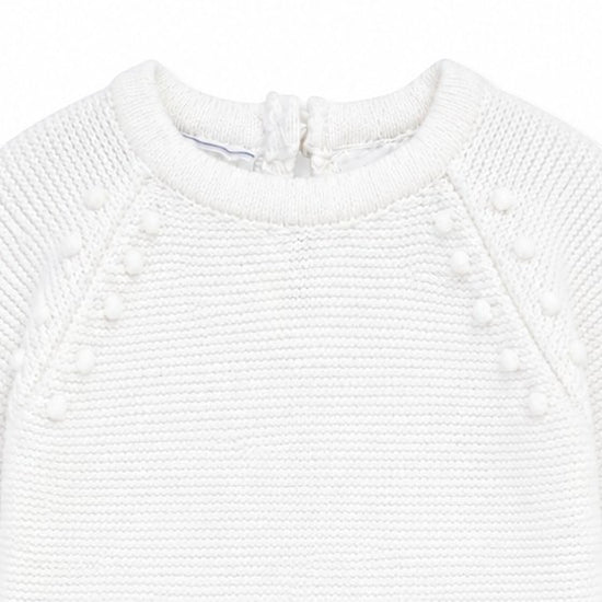 Carriage Boutique white knit baby romper with delicate leaf and pom-pom detailing for christening or special occasions.