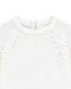 Carriage Boutique white knit baby romper with delicate leaf and pom-pom detailing for christening or special occasions.