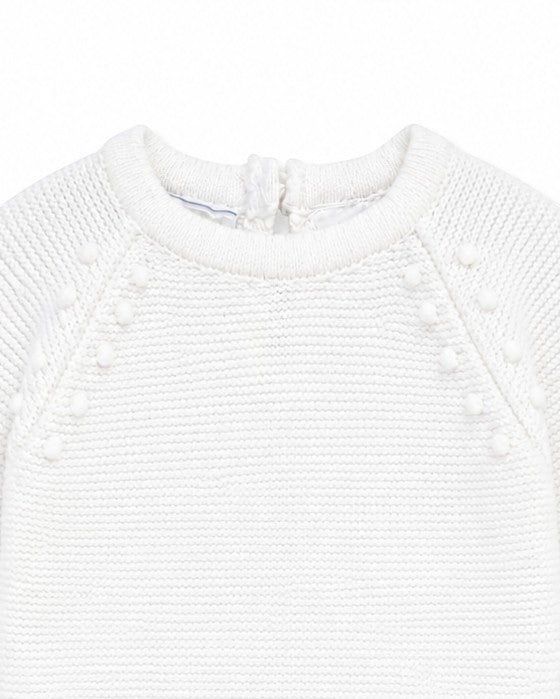 Carriage Boutique white knit baby romper with delicate leaf and pom-pom detailing for christening or special occasions.
