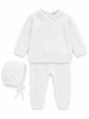 Carriage Boutique white knit baptism outfit for baby boys featuring a pearl cross, collared top, pants, and bonnet.