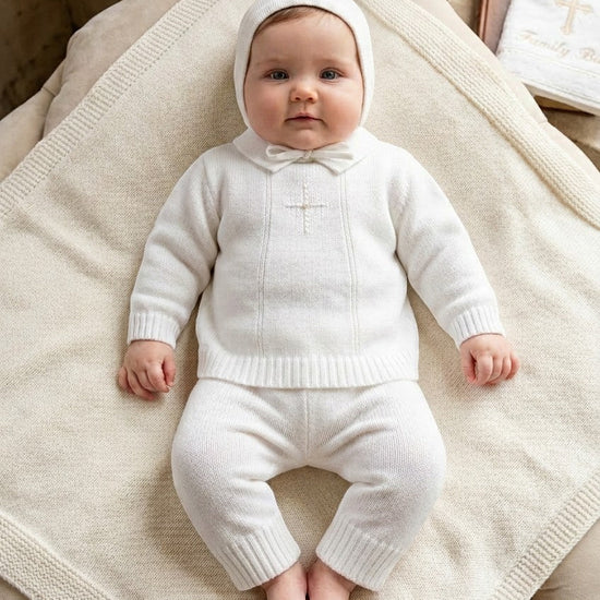 Carriage Boutique baby boy wearing a white knit baptism outfit with pearl cross detail and matching bonnet
