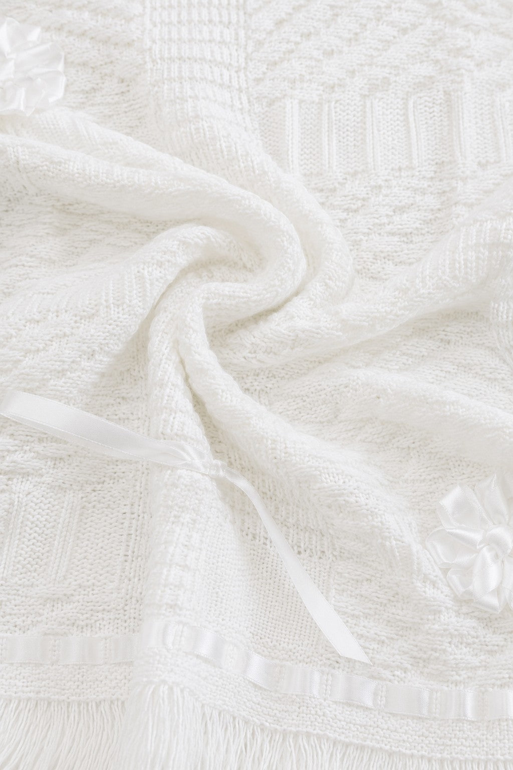 Carriage Boutique white knit christening blanket with satin ribbon bows and delicate textured pattern